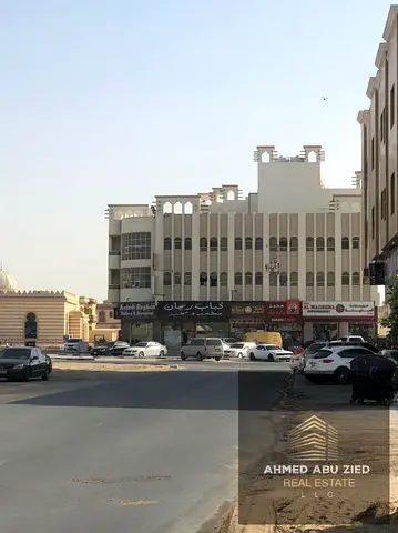 بناية استثمارية زاوية للبيع في الروضة 2 عجمان على شارع رئيسي، دخل سنوي 950 ألف درهم، مؤجرة بالكامل، 11 محل و30 وحدة سكنية، فرصة استثمارية بعائد قوي