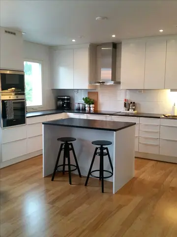 Modern white kitchen island with black countertop and storage