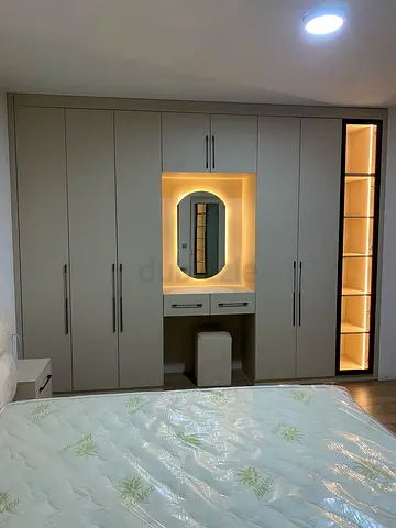 Built-in bedroom wardrobe with illuminated vanity and display shelving