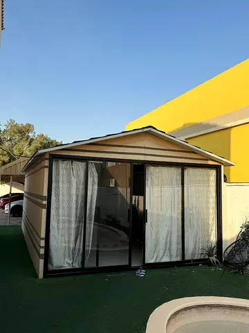 Portable garden sunroom / enclosed gazebo with sliding glass panels