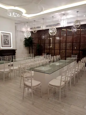 Set of white chiavari banquet chairs (multiple) and glass-top banquet tables