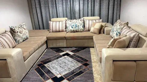 Large L-shaped beige sectional sofa with cushions - good condition