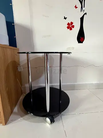 Small black round side table with chrome legs and lower shelf