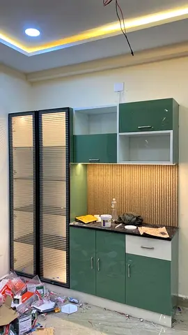 Green and white kitchen cabinet set with glass display and countertop