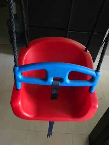 Red plastic baby toddler swing seat with safety strap