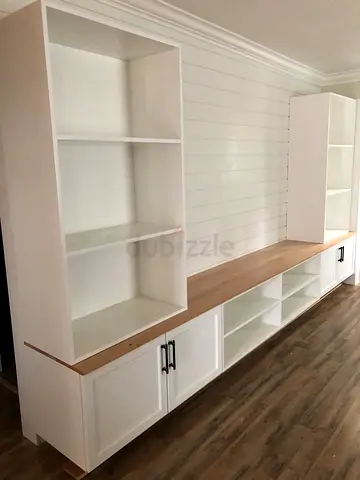 Custom built-in white entertainment unit with open shelves and cabinets