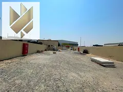 A warehouse for rent in Al Sajaa with an open yard and a prime industrial location.