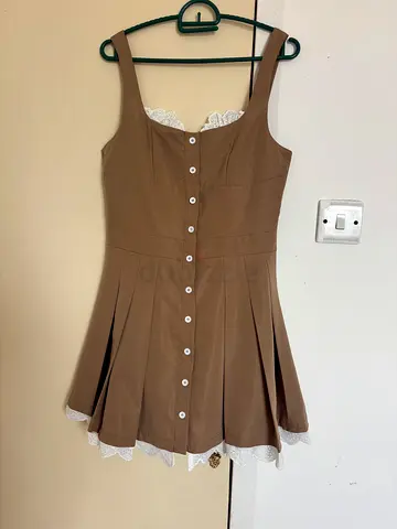 Brown sleeveless dress with lace trim and pleated skirt