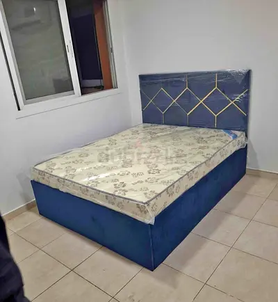 Blue Upholstered Bed Frame with Patterned Headboard and Mattress