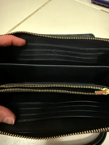 Black zip-around leather wallet with multiple card slots and coin pocket