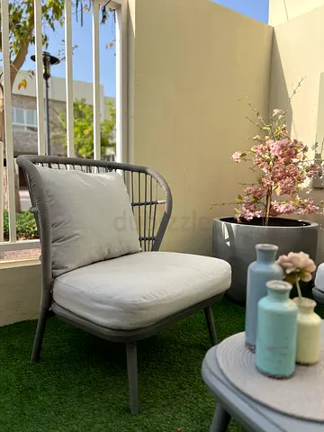 Outdoor rattan-style lounge chair with cushions