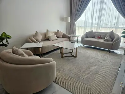 Light beige curved sofa set with armchair and large rug — good condition