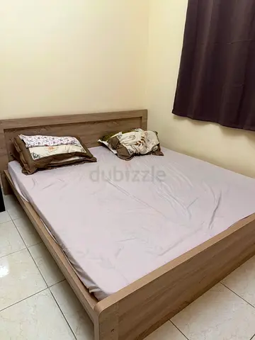 Simple wooden queen bed frame in light oak - good condition.