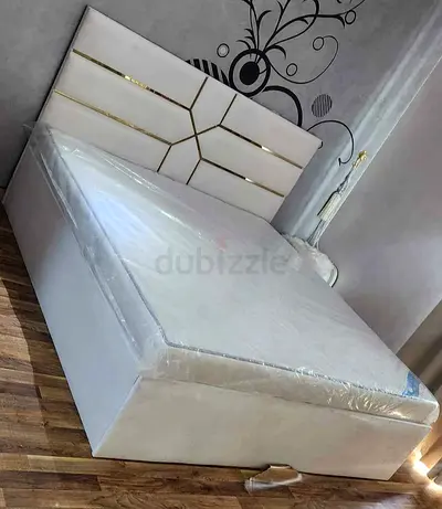 Modern White Bed with Padded Headboard and Gold Details