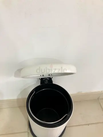 Small white kitchen countertop trash bin with swing lid