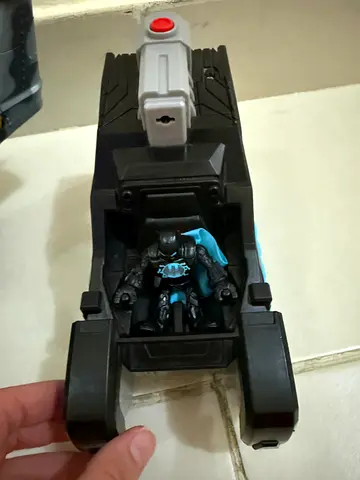 Small black toy vehicle with detachable blue action figure