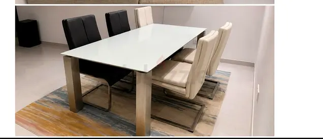 Modern glass-top dining table with 6 leather chairs and rug
