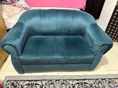 Two-seater velvet teal sofa in good condition