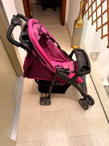 Lightly used pink baby stroller - compact and foldable