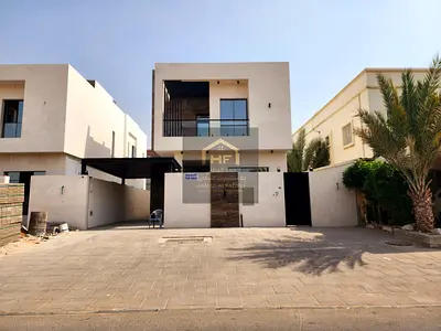 A brand new villa in Al Muwaihat 2 is for sale, directly next to the mosque, on a paved road, with a 10-meter front setback for outdoor parking. The l