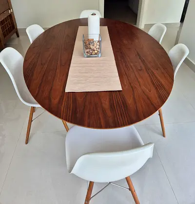Modern Oval Wooden Dining Table with 6 White Chairs and a floor lamp.