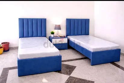 Pair of Blue Single Beds with Upholstered Headboards and Nightstand