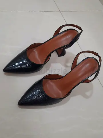 Black Jade leather heels feature a distinct crocodile-effect texture and a classic slingback design