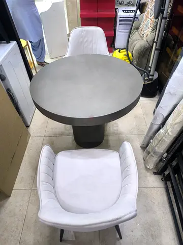 Round concrete. dining table with two white upholstered chairs - set of 3