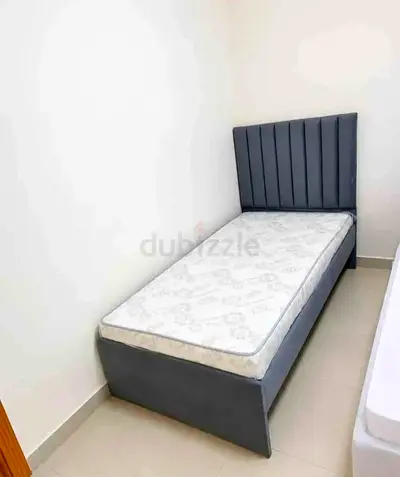 Single bed with grey fabric headboard and mattress