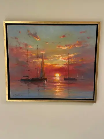 Oil painting of sailboats at sunset in gilt frame