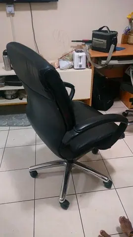 Black leather swivel office chair with armrests and wheels - used