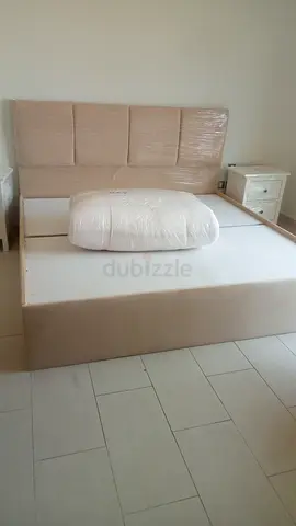 Beige fabric queen bed frame with headboard and mattress