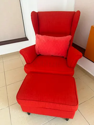 Red upholstered wingback armchair with matching ottoman