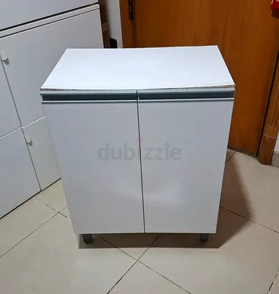Small white kitchen cabinet with doors — compact storage unit
