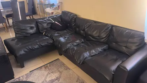 Black L-shaped faux leather sofa — comfortable sectional, good condition