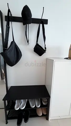 Black wall-mounted coat rack with bench and shoe storage