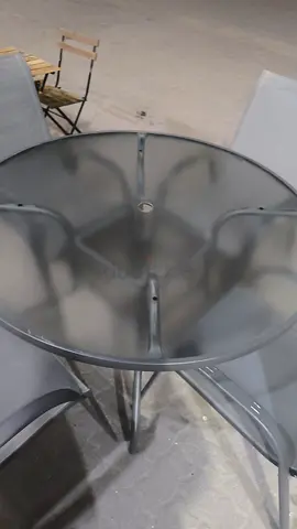 Glass-top round patio table with 4 matching mesh chairs