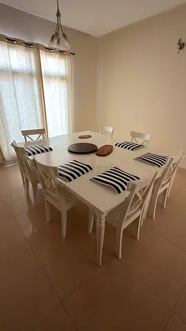White wooden 6 or 8-seater dining table with 8 chairs — good condition