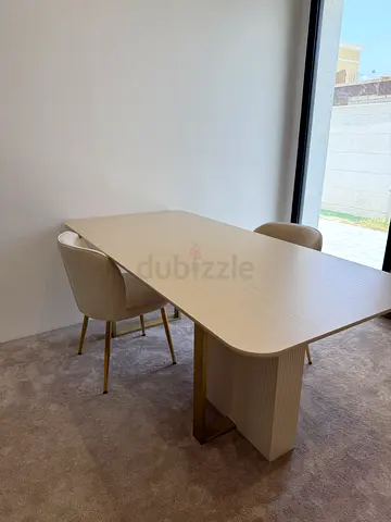 Light wood dining table with two beige chairs - modern set