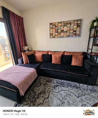 L-shaped velvet sofa with chaise, black with rose accents