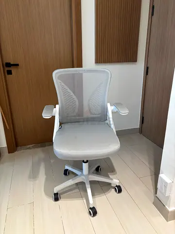 White ergonomic mesh office chair with adjustable armrests