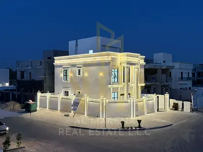 Corner villa for sale in Ajman, two floors and a roof terrace, situated on two streets with a large setback in a prime residential location near a mos