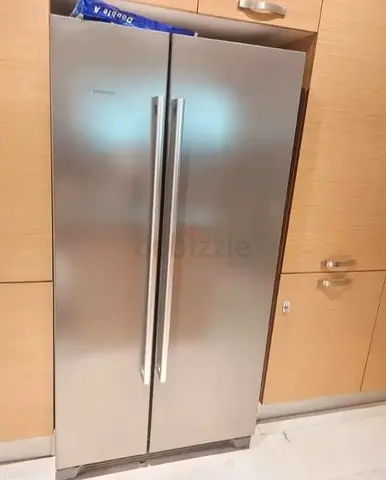 Siemens side-by-side stainless steel refrigerator, likely model KA56NV40NE with 618-liter capacity.F