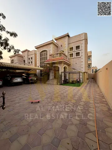 A distinctive villa for sale in Al Rawda 2, strategically located on a street and alley, directly next to the mosque | Land area 5000 sq ft, built-up