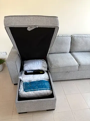Light grey fabric sectional sofa with storage ottoman
