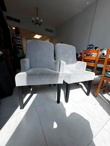 Pair of light grey upholstered dining chairs with armrests