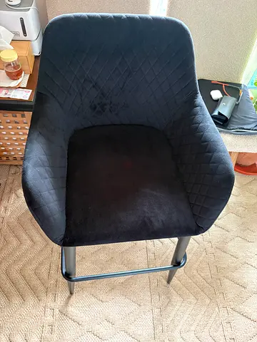 Velvet-upholstered counter/bar stools with a diamond quilted back and black metal legs