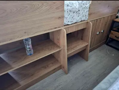 Wooden built-in kids bed with under-shelf storage and cabinets