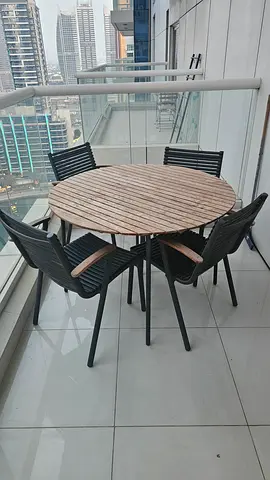 Outdoor round wooden dining table with 4 black chairs - good condition