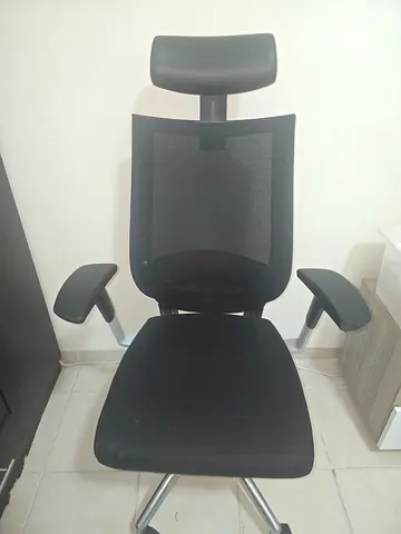 Black ergonomic office chair with headrest and armrests